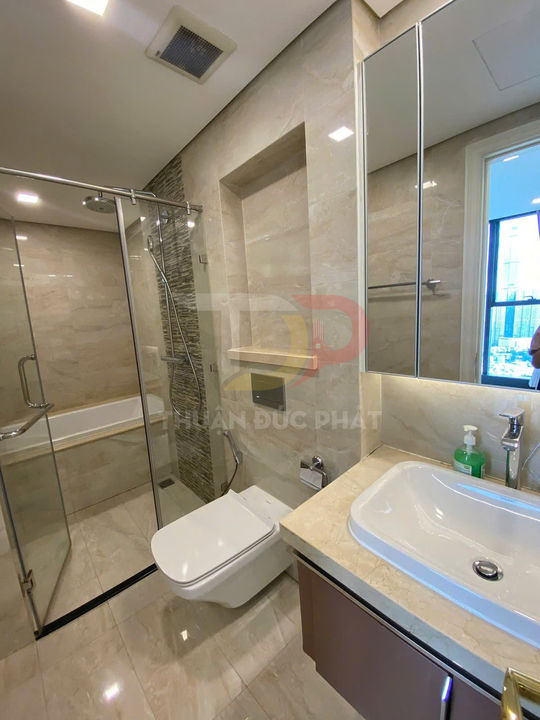 Phòng tắm hiện đại với bồn rửa mặt, bồn cầu treo tường và buồng tắm kính có vòi sen đứng