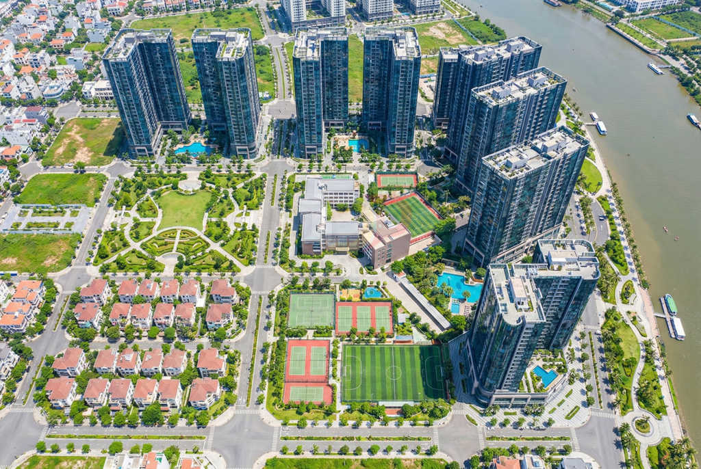 Khu căn hộ cao cấp ven sông với nhiều tòa nhà cao tầng, sân thể thao và hồ bơi nhìn từ trên cao
