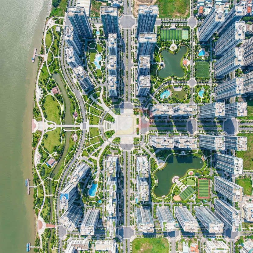 Khu đô thị cao tầng hiện đại nhìn từ trên cao với nhiều tòa chung cư, công viên và hồ nước cạnh sông