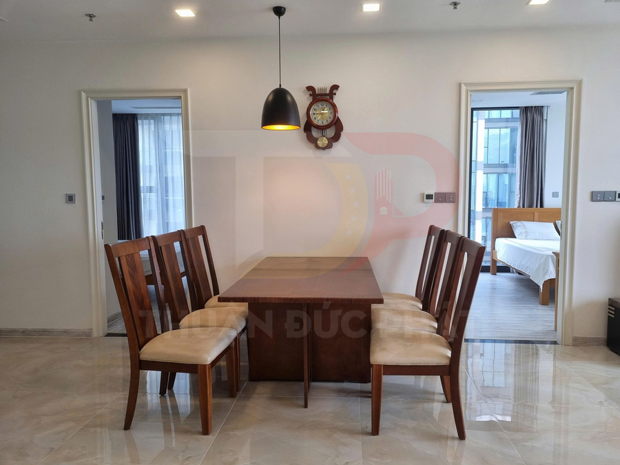 Bộ bàn ăn gỗ 6 ghế đệm nỉ trong căn hộ hiện đại, đèn thả trần và đồng hồ treo tường trang trí