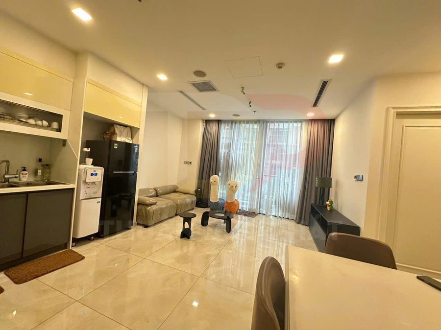 Phòng khách căn hộ hiện đại với sofa da, tủ lạnh, máy lọc nước và đồ chơi trẻ em trên sàn