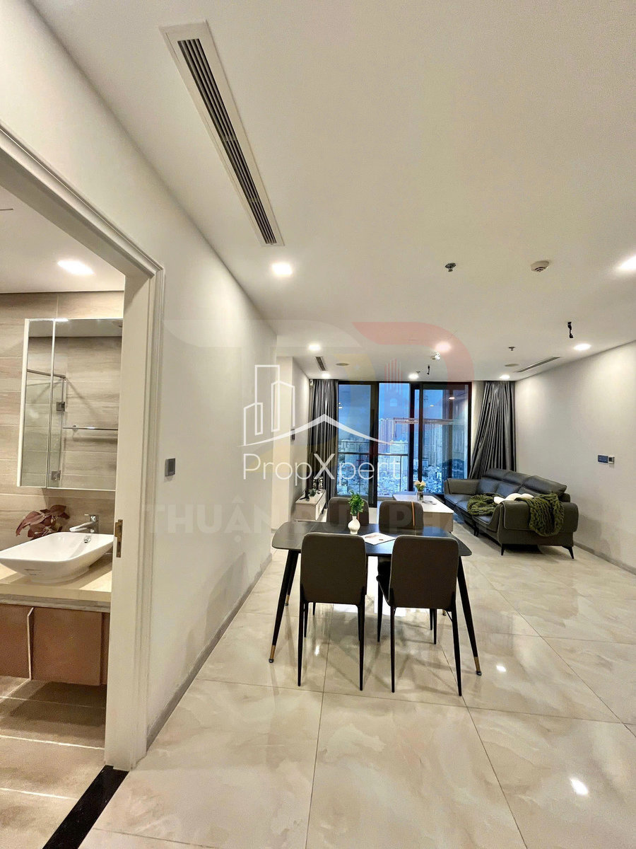 Căn hộ hiện đại với phòng khách liền bếp, bàn ăn bốn ghế và sofa cạnh cửa kính lớn