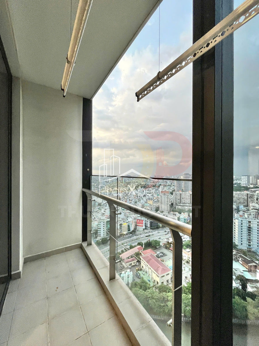 Ban công căn hộ chung cư cao tầng với lan can kính nhìn ra toàn cảnh thành phố đông đúc
