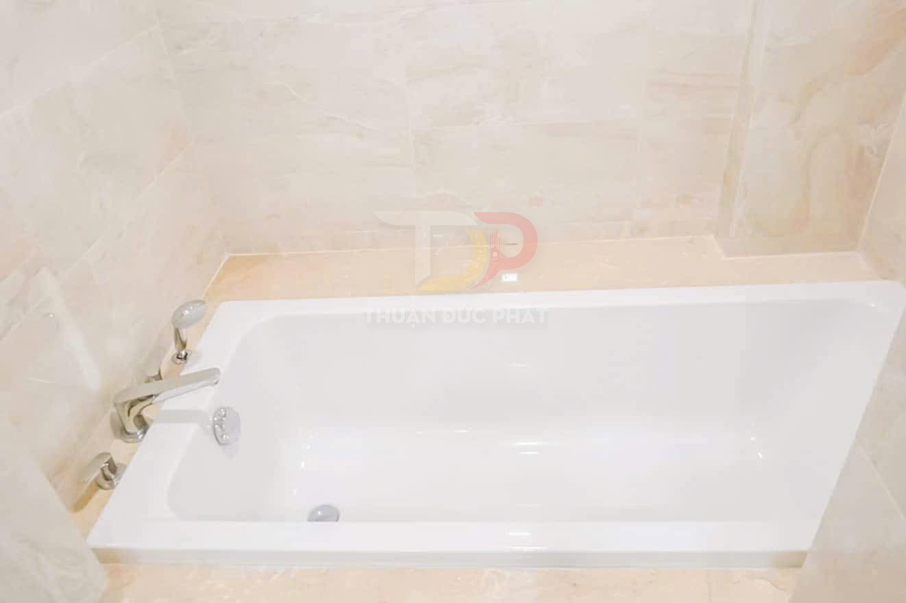 Bồn tắm nằm màu trắng hiện đại với vòi nước inox lắp âm tường trong phòng tắm ốp đá sáng