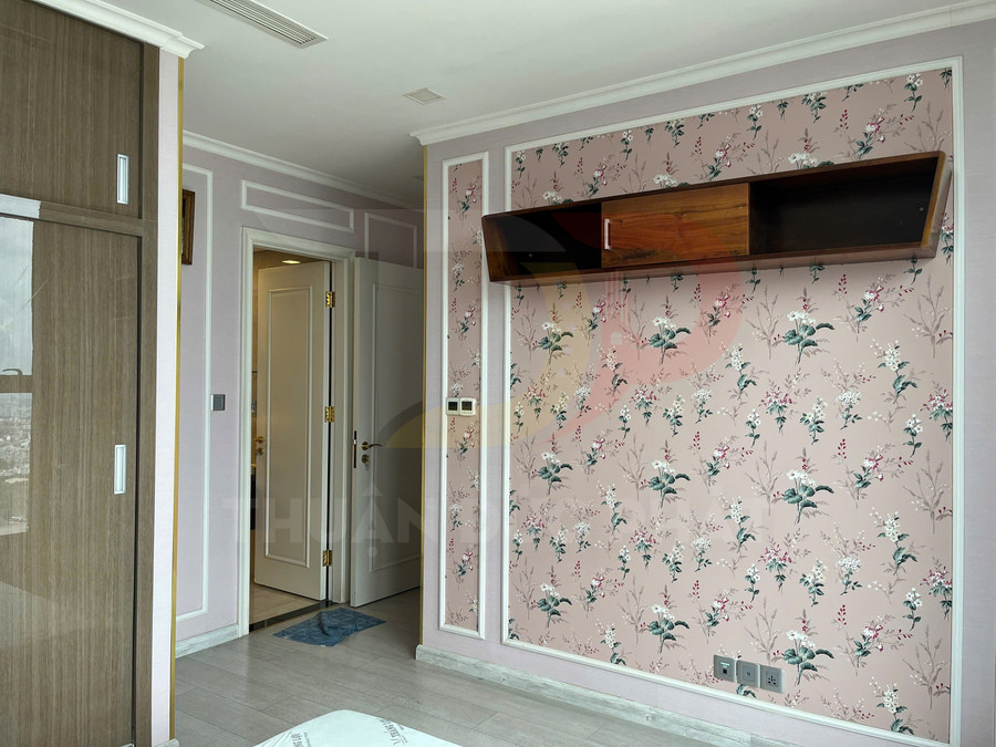 Kệ gỗ treo tường trong phòng ngủ với giấy dán tường hoa màu hồng pastel
