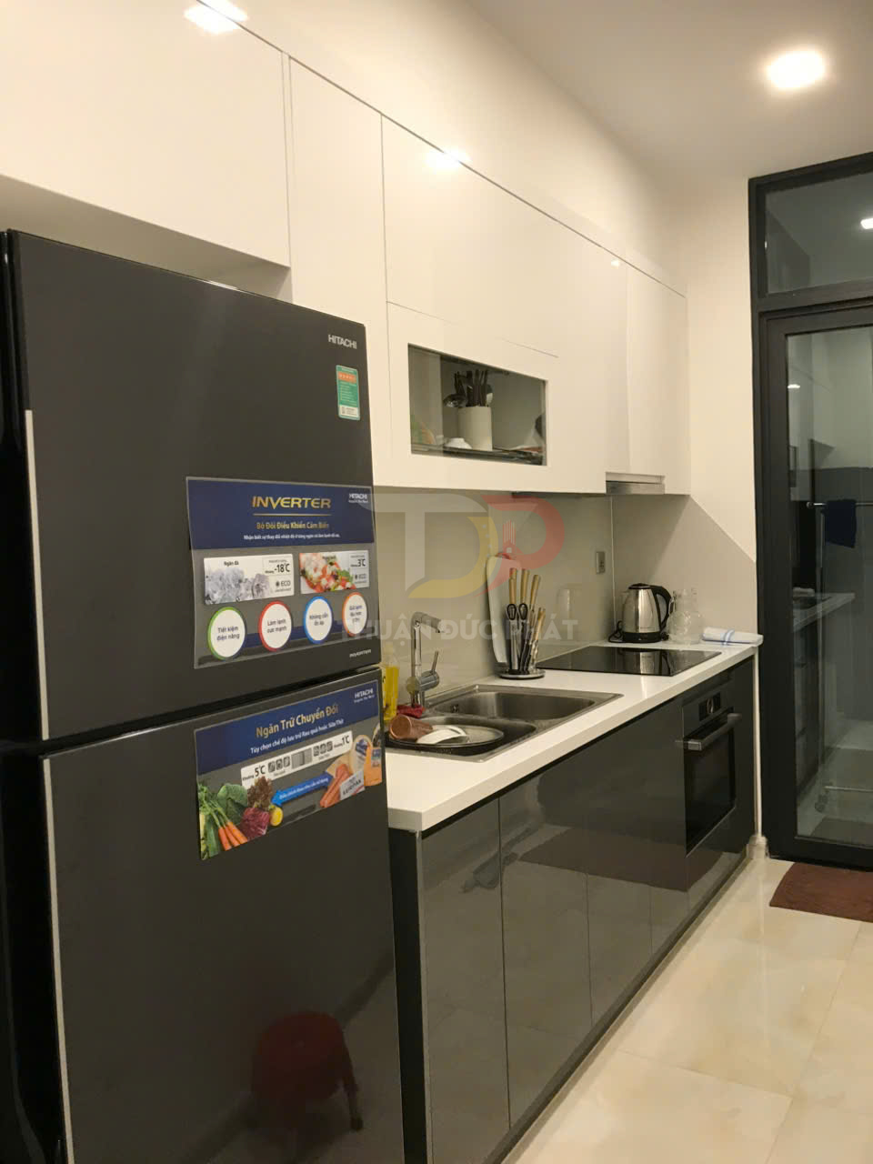 Tủ lạnh Hitachi inverter màu đen trong căn bếp hiện đại với tủ bếp và bồn rửa cạnh bếp điện