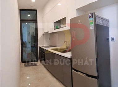 Bếp nhỏ hiện đại với tủ bếp trắng xám, bồn rửa inox và tủ lạnh hai cửa màu bạc