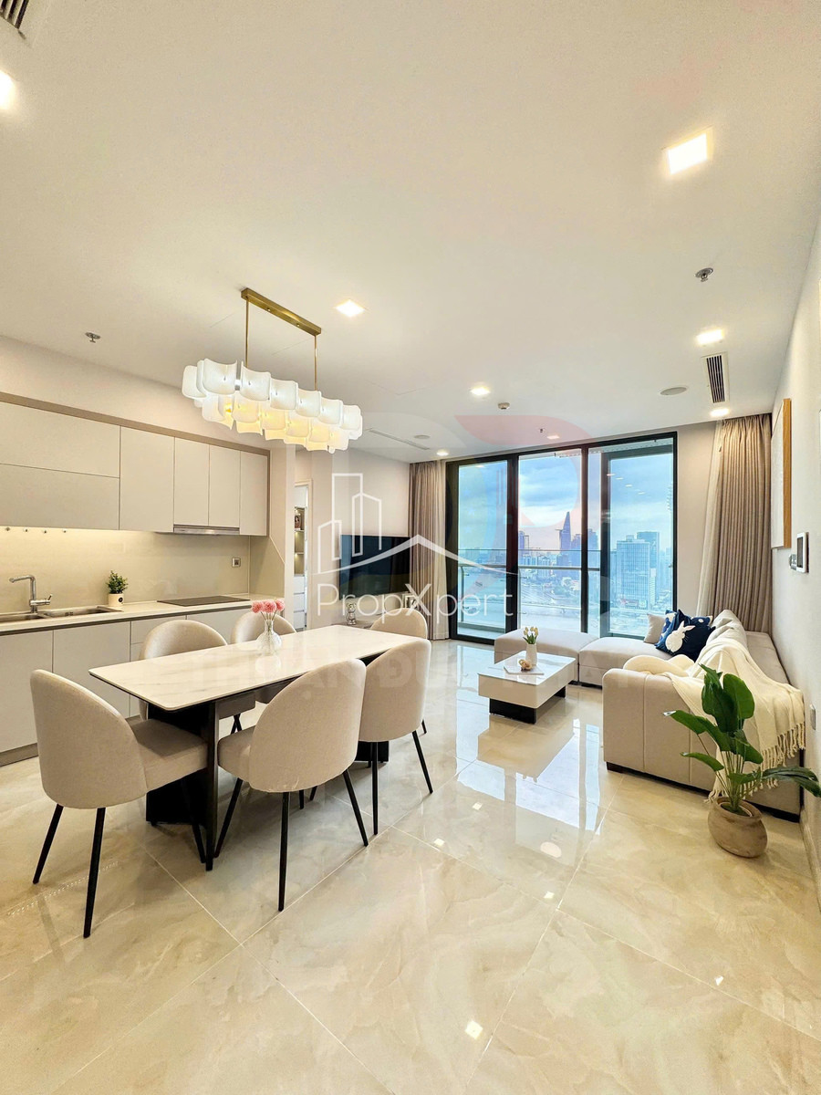Phòng khách căn hộ cao cấp với sofa chữ L, bàn ăn 4 ghế và cửa kính lớn nhìn ra thành phố