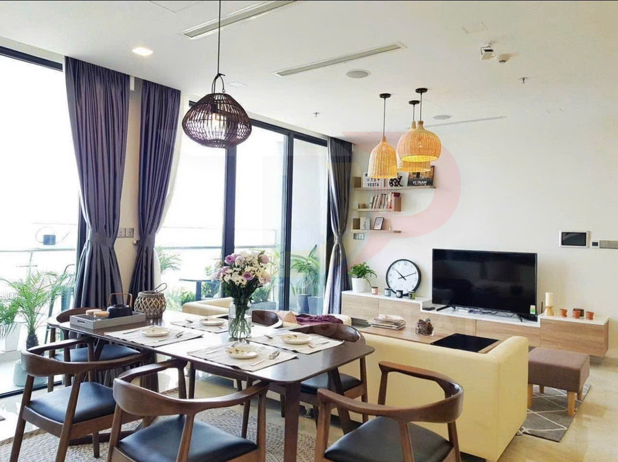Phòng khách và bàn ăn gỗ hiện đại với sofa sáng màu, tivi màn hình phẳng và cửa kính lớn nhiều ánh sáng