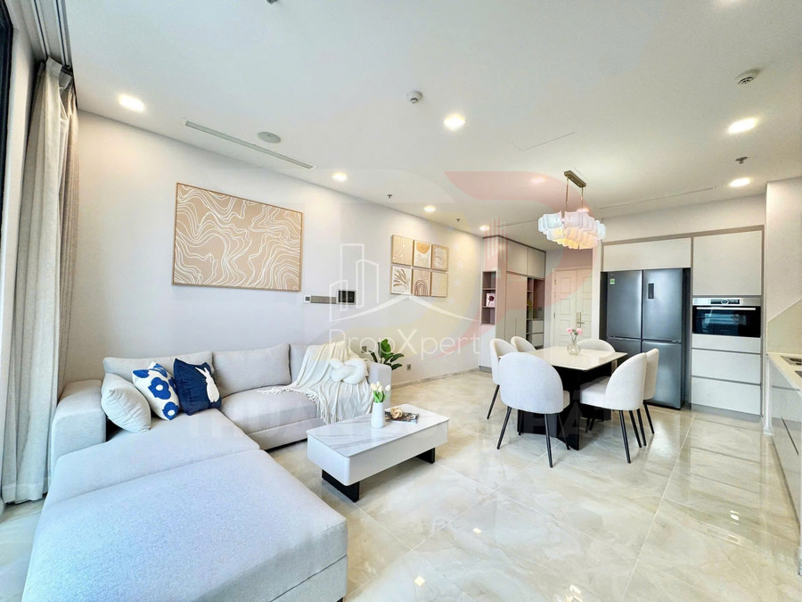 Phòng khách và bếp chung cư hiện đại với sofa chữ L, bàn trà, bàn ăn và tủ bếp tông trắng sáng