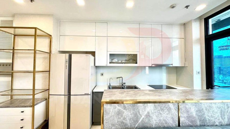 Bếp hiện đại với tủ bếp trắng, tủ lạnh hai cánh, bồn rửa inox và bàn đảo mặt đá marble