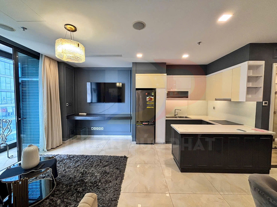 Phòng bếp và phòng khách chung cư hiện đại với tủ bếp chữ L, đảo bếp và tivi treo tường