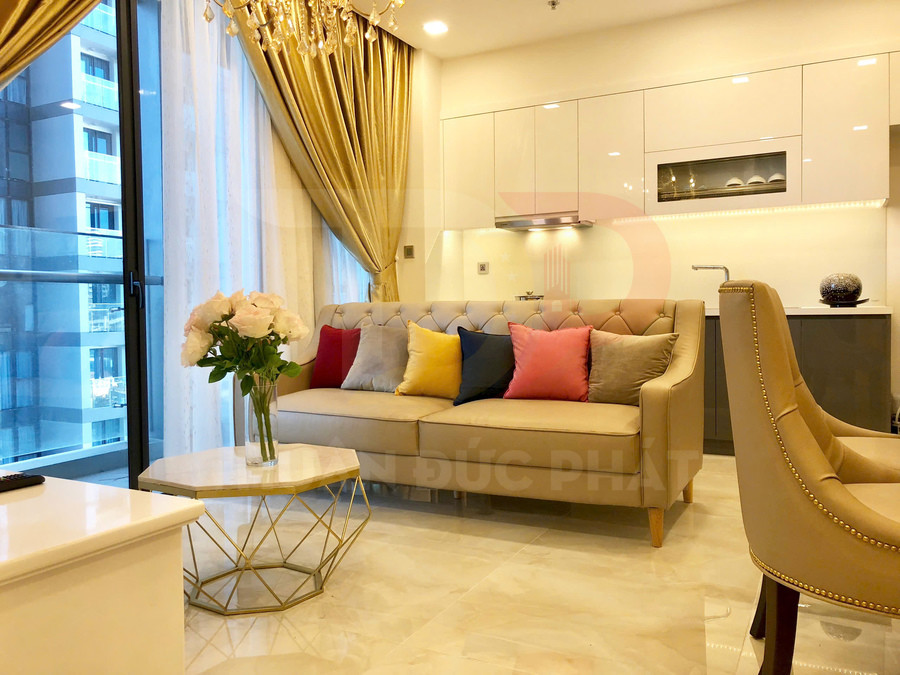 Sofa phòng khách màu be với gối tựa nhiều màu, bàn trà mặt đá và rèm vàng trong căn hộ hiện đại