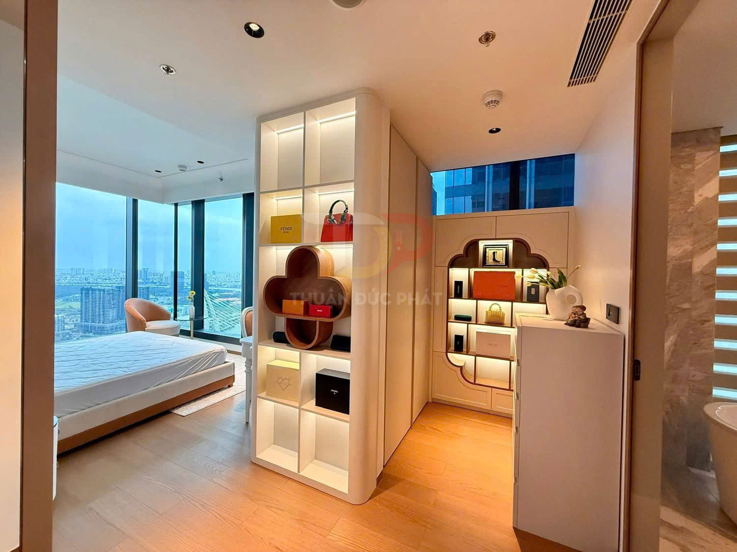 Tủ kệ trang trí phòng ngủ hiện đại với nhiều hộp quà và túi xách trưng bày cạnh cửa sổ kính lớn