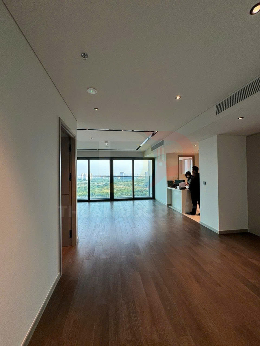 Căn hộ mới với sàn gỗ, phòng khách rộng và cửa kính lớn nhìn ra cảnh quan xanh