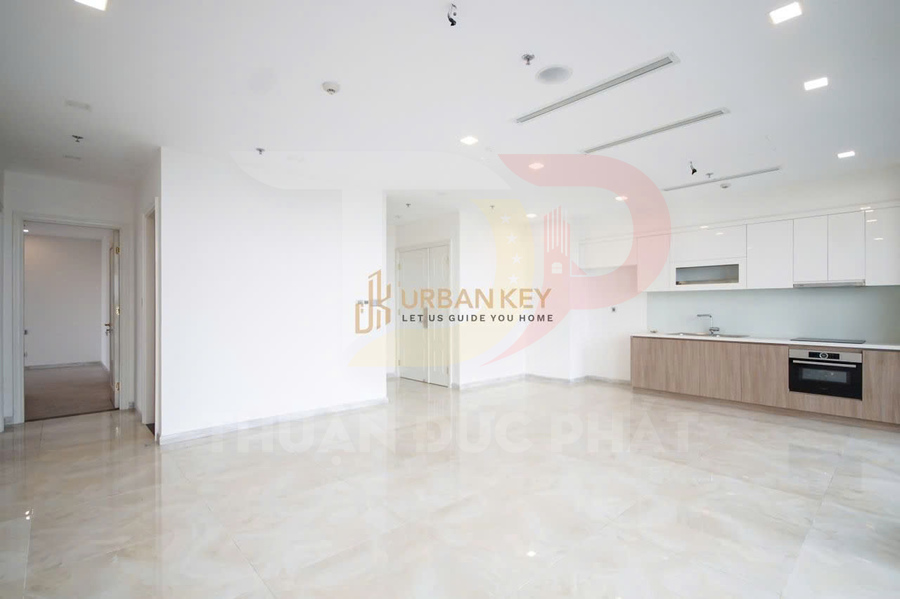 Căn hộ mới bàn giao với phòng khách liền bếp, tủ bếp gỗ sáng và sàn gạch bóng hiện đại