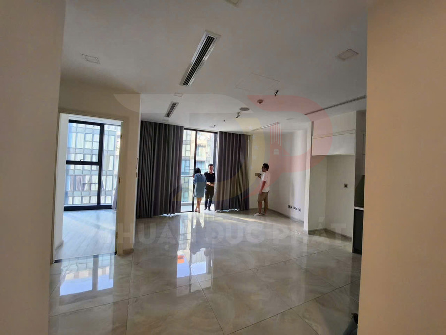 Căn hộ trống mới bàn giao với phòng khách lát gạch bóng, cửa kính lớn và rèm tối màu