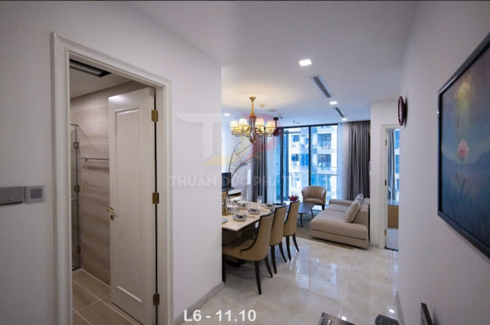 Phòng khách và phòng ăn căn hộ chung cư hiện đại với bàn ăn, sofa và cửa kính lớn nhìn ra ban công