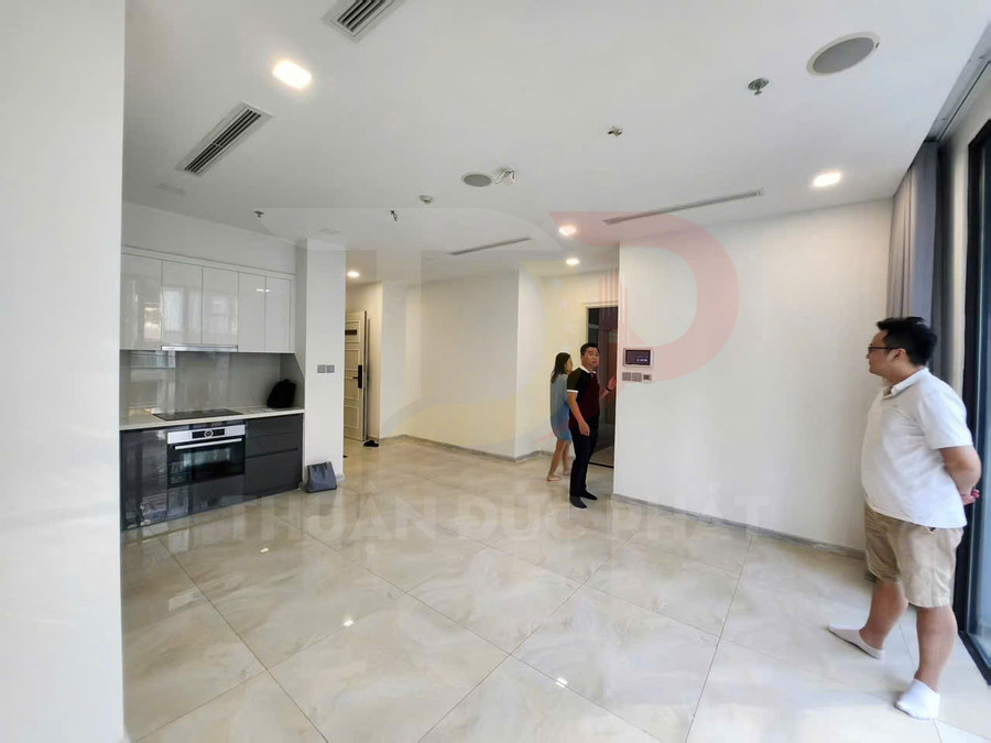 Căn hộ mới với bếp âm tường hiện đại, sàn gạch sáng bóng và cửa kính lớn nhìn ra ngoài