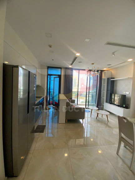 Căn hộ hiện đại với bếp, tủ lạnh lớn, phòng khách sofa và tivi gần cửa kính ban công rộng