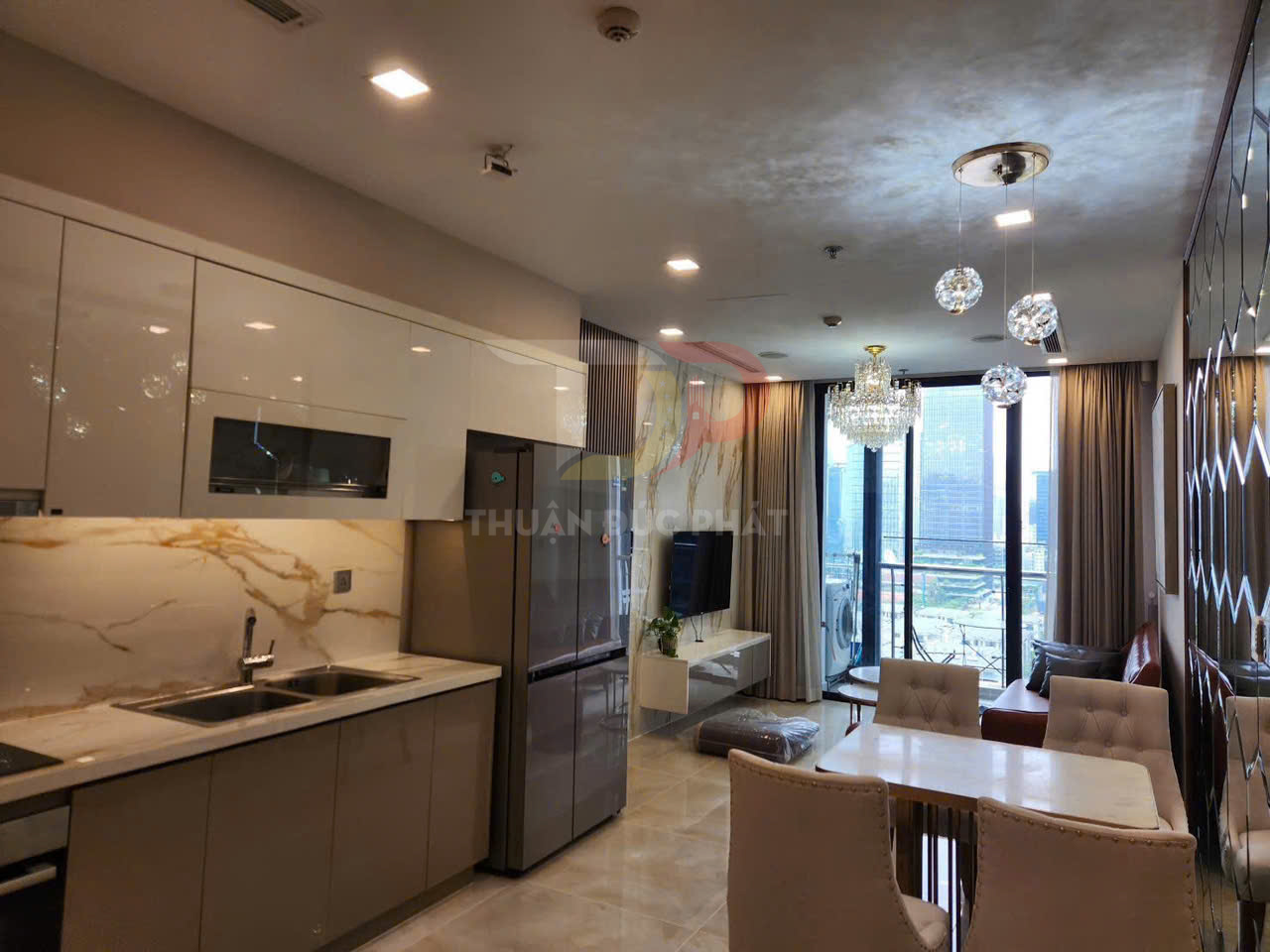 Căn hộ cao cấp với bếp liền phòng khách, bàn ăn và cửa kính lớn nhìn ra thành phố