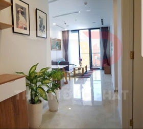 Phòng khách căn hộ hiện đại với cửa kính lớn, sofa, bàn trà gỗ và cây xanh trang trí