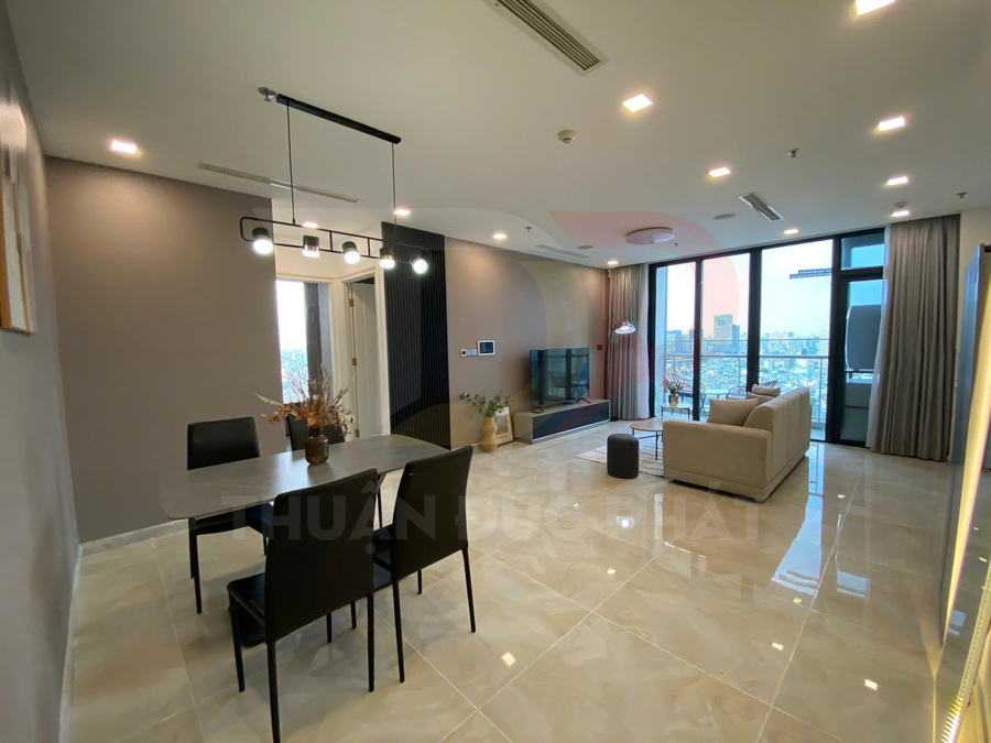 Phòng khách căn hộ cao cấp với sofa, bàn ăn hiện đại và cửa kính lớn nhìn ra thành phố