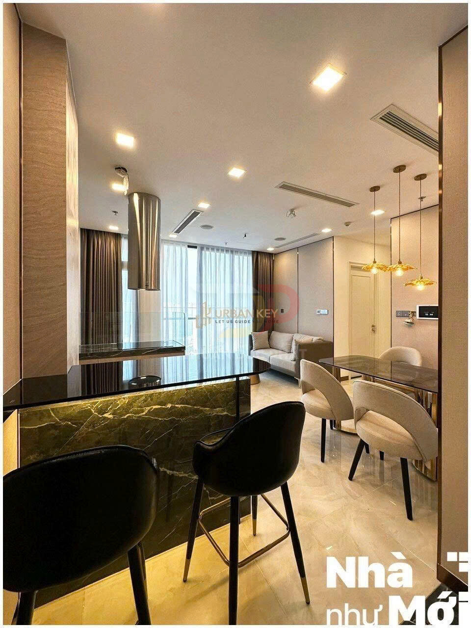 Phòng khách căn hộ hiện đại với quầy bar đá, ghế cao đen, bàn ăn và sofa cạnh cửa kính lớn
