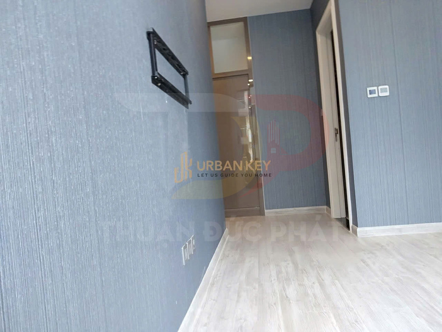 Căn hộ mới với tường màu xanh xám, sàn gỗ sáng màu và giá treo tivi gắn tường