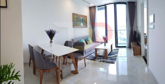 Phòng khách căn hộ hiện đại với sofa xám, bàn ăn gỗ và cửa kính lớn đón ánh sáng tự nhiên