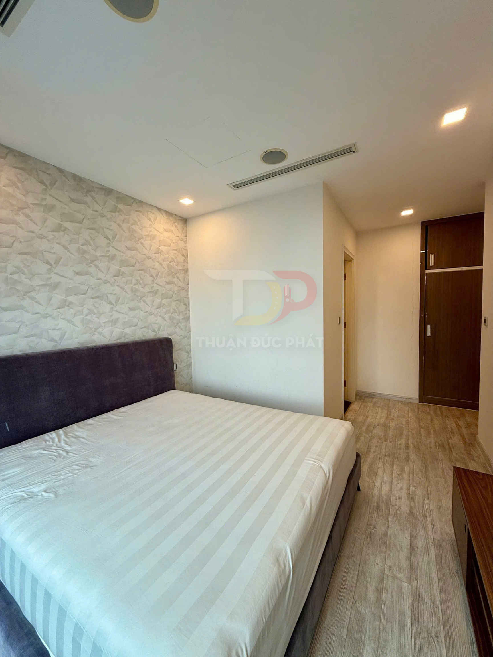 Phòng ngủ hiện đại với giường đôi bọc nệm màu tím và ga trải giường trắng sọc