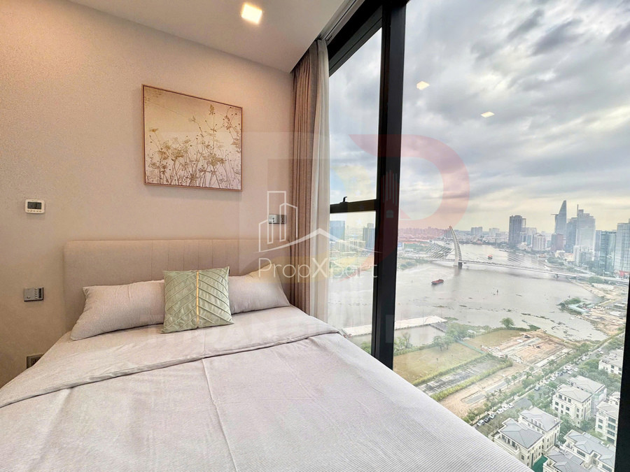 Phòng ngủ chung cư hiện đại với giường đôi cạnh cửa sổ lớn nhìn ra sông và skyline thành phố