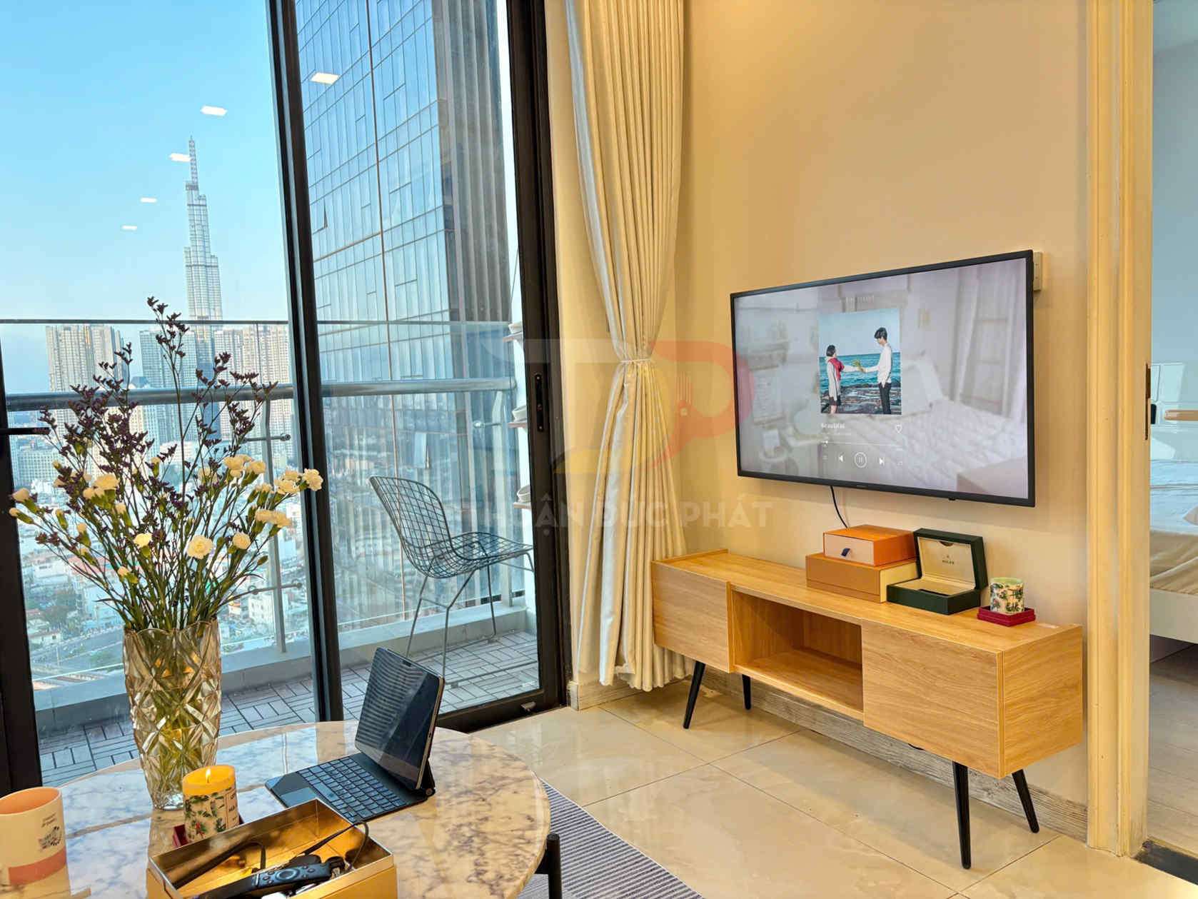 Kệ tivi gỗ hiện đại chân cao đặt dưới tivi treo tường trong phòng khách căn hộ view thành phố