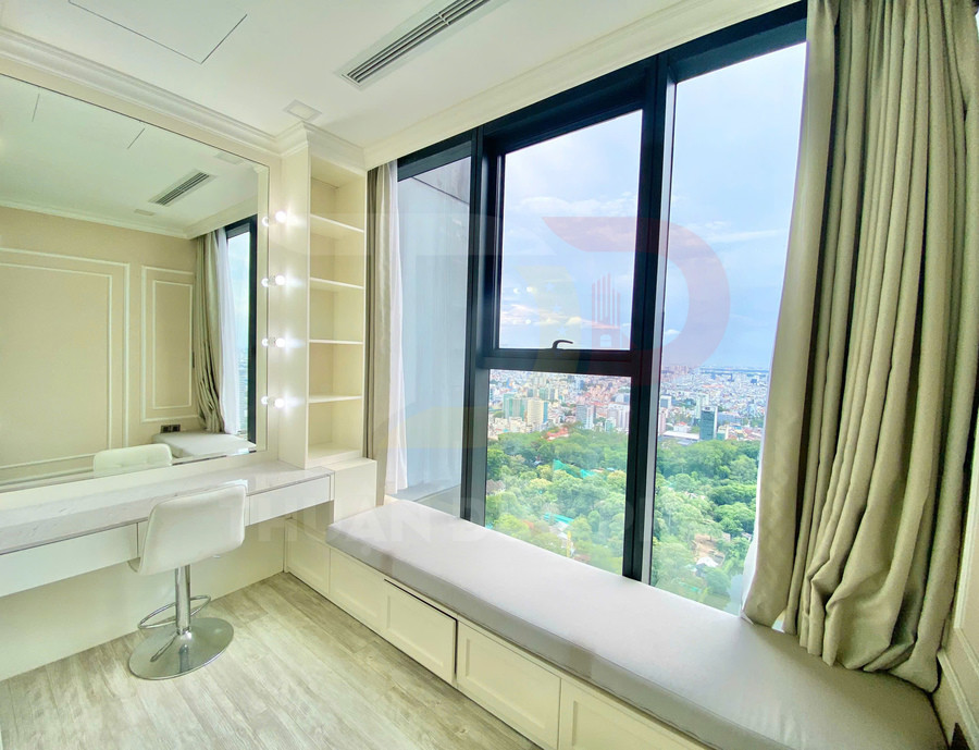 Bàn trang điểm hiện đại cạnh cửa sổ kính lớn với ghế trắng và bệ ngồi nhìn ra thành phố