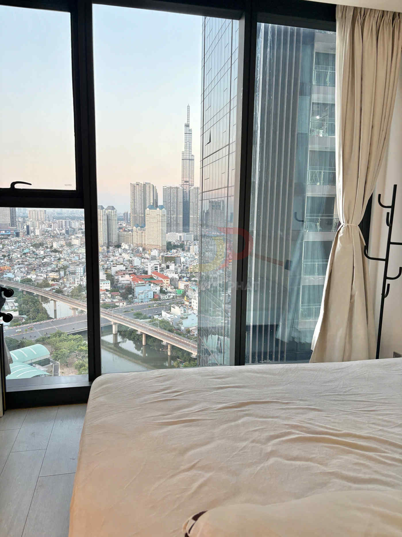 Phòng ngủ chung cư với giường cạnh cửa sổ lớn, view sông và tòa Landmark 81 tại TP HCM