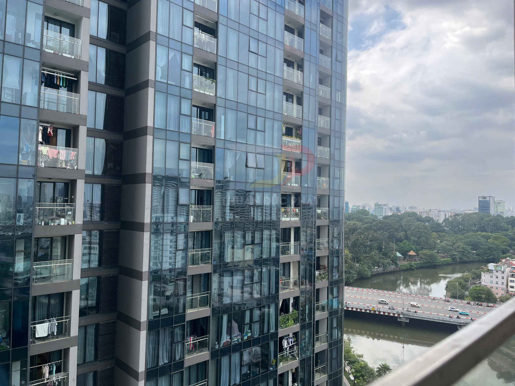 Căn hộ chung cư cao tầng mặt kính lớn nhìn ra sông và cầu trong khu đô thị đông đúc