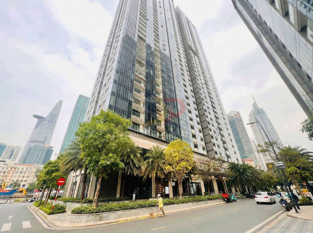 Tòa nhà chung cư cao tầng mặt tiền đường lớn với hàng cây xanh và xe cộ phía trước