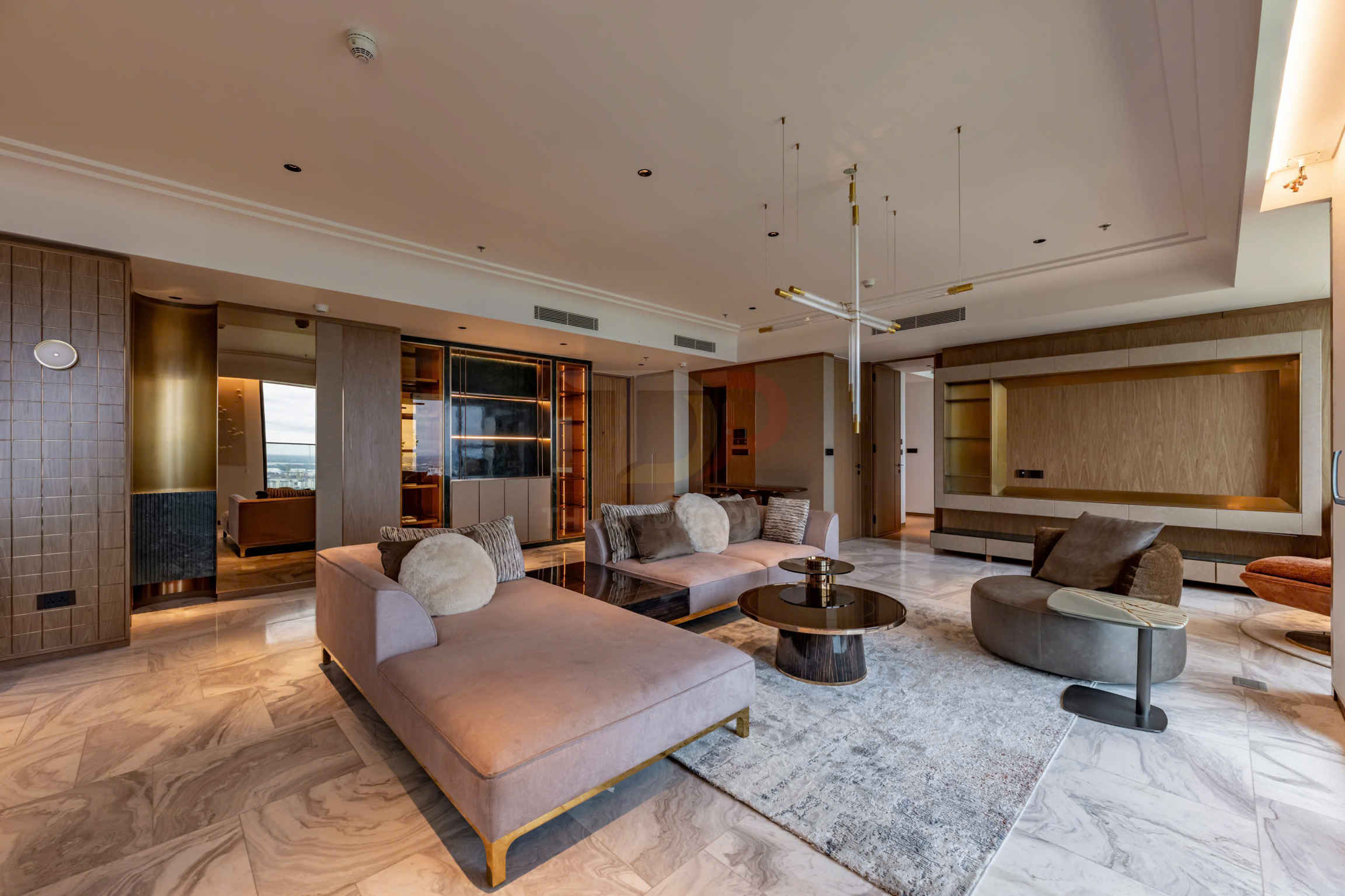 Phòng khách chung cư cao cấp với sofa lớn màu be, bàn trà tròn và đèn trần hiện đại