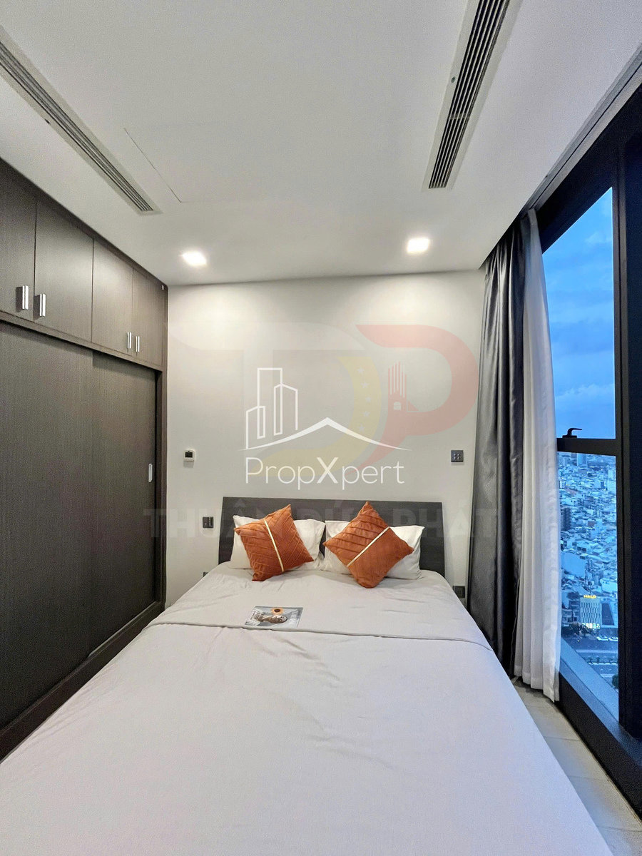 Phòng ngủ chung cư hiện đại với giường đôi ga xám, gối cam, tủ âm tường gỗ và cửa sổ lớn view thành phố