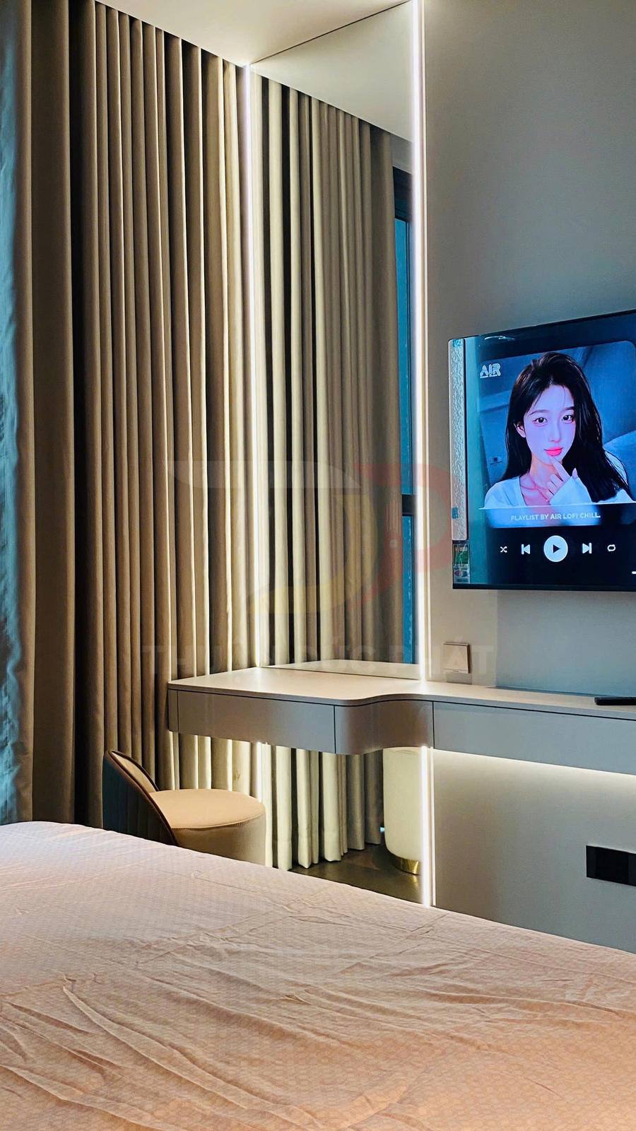 Rèm cửa phòng ngủ cao cấp màu be bên cạnh bàn làm việc và tivi treo tường hiện đại