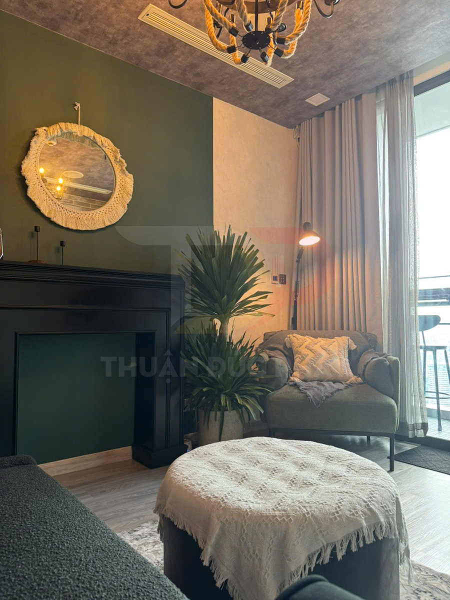 Ghế sofa đơn màu xanh với gối tựa, bàn tròn phủ khăn ren trong phòng khách phong cách hiện đại ấm cúng