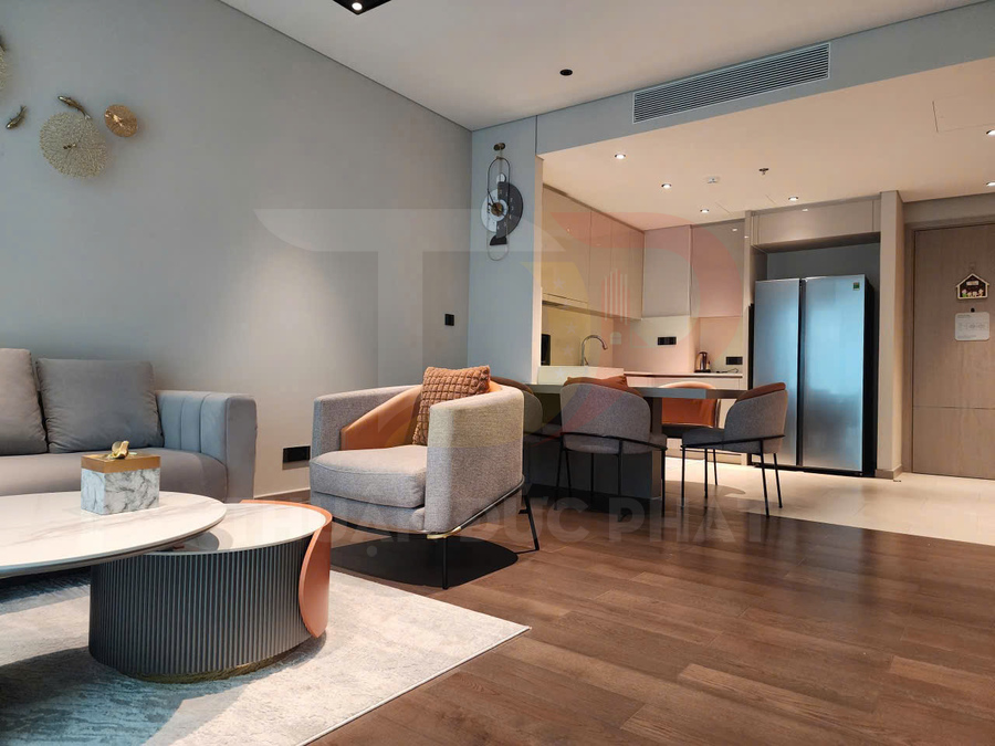 Phòng khách và bếp hiện đại với sofa xám, bàn trà mặt đá, bộ bàn ăn và tủ lạnh đôi inox