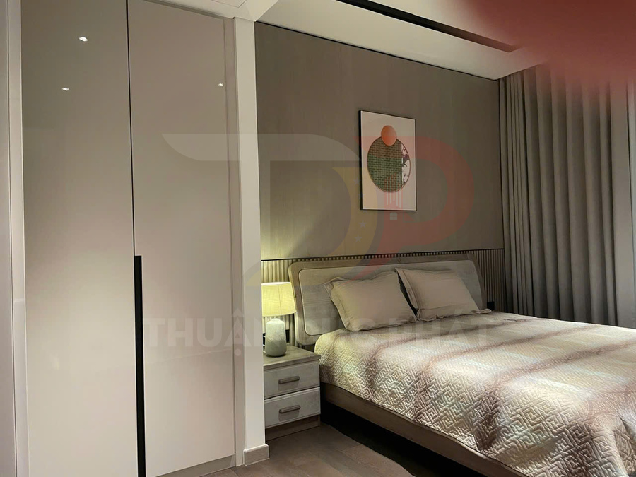 Phòng ngủ hiện đại với giường đôi bọc nệm, tủ quần áo cửa lùa và đèn ngủ trên tab đầu giường