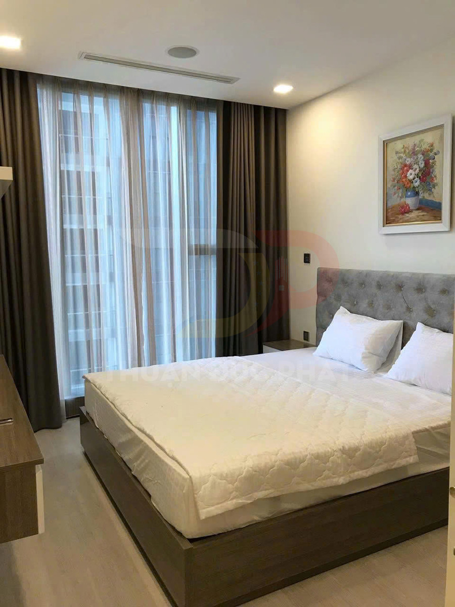 Phòng ngủ hiện đại với giường gỗ bọc nệm trắng, rèm cửa lớn và tranh treo tường trang trí