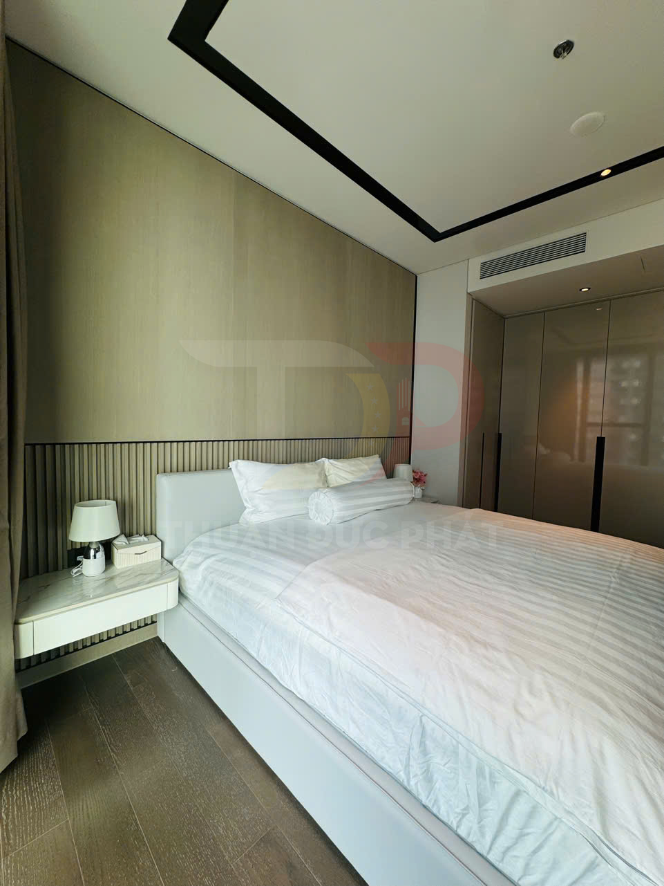 Giường ngủ hiện đại với ga trắng, tab đầu giường và tủ quần áo âm tường trong phòng ngủ tối giản