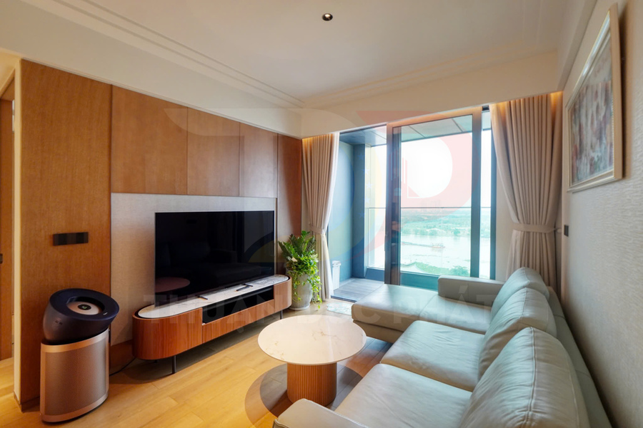 Phòng khách chung cư hiện đại với sofa da, bàn trà tròn, tivi màn hình phẳng và cửa kính lớn nhìn ra ban công