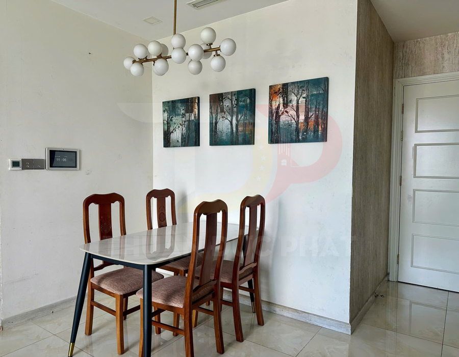 Bộ bàn ăn mặt đá với bốn ghế gỗ bọc nệm trong phòng ăn hiện đại treo tranh phong cảnh