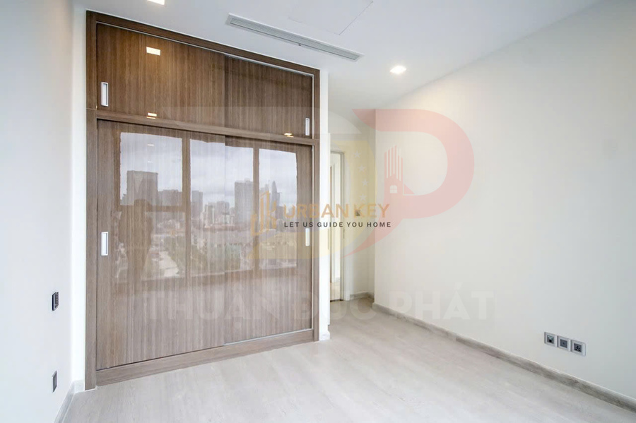 Phòng ngủ trống với tủ quần áo âm tường cửa trượt gỗ hiện đại và sàn gỗ sáng màu