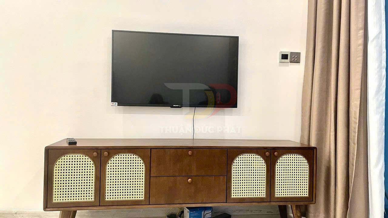 Kệ tivi gỗ kiểu dáng hiện đại đặt dưới tivi Sony treo tường trong phòng khách