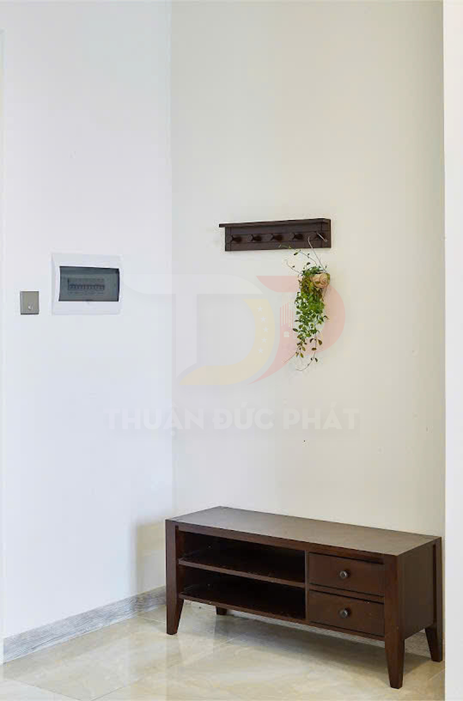 Kệ tivi gỗ màu nâu thiết kế đơn giản với hai ngăn kéo và kệ mở đặt sát tường phòng khách